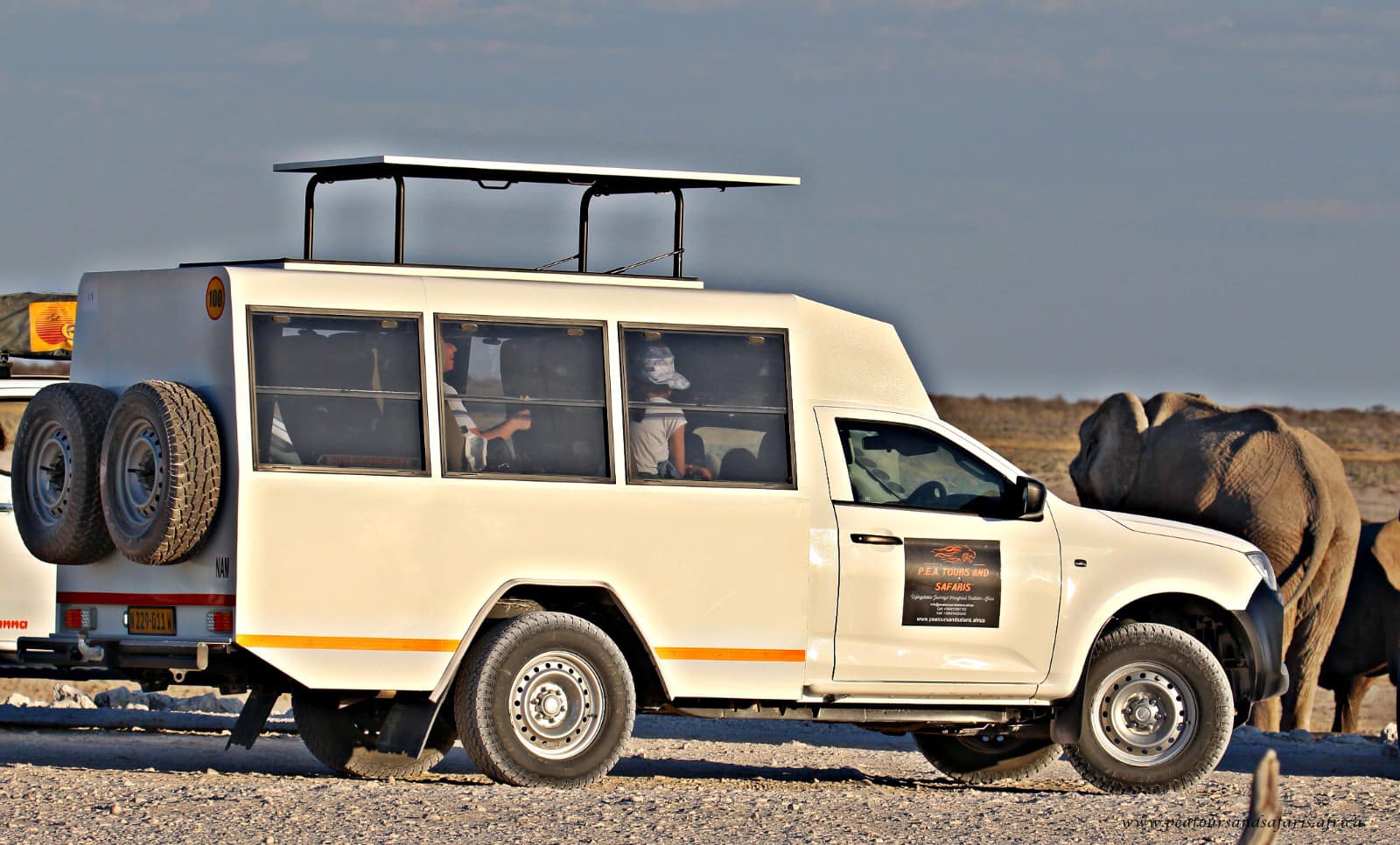 PEA Tours and Safaris custom 4x4 vehicle with guests viewing an elephant during a guided game drive in Etosha National Park, Namibia